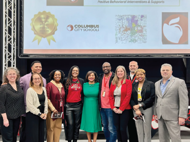 group of educators standing in front of a projection screen